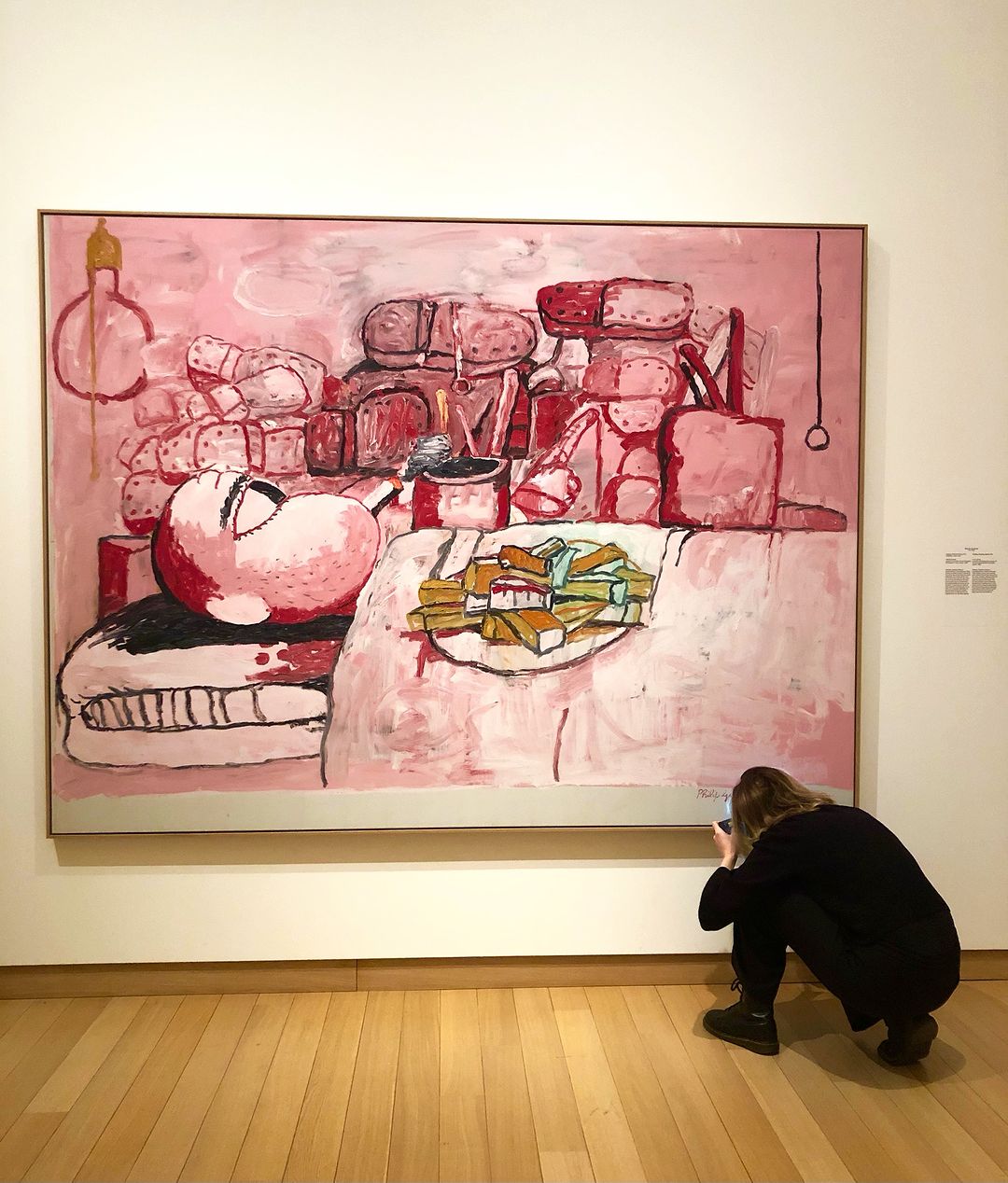 Foto van het werk van Guston op zaal, met een conditiecheck door restaurator