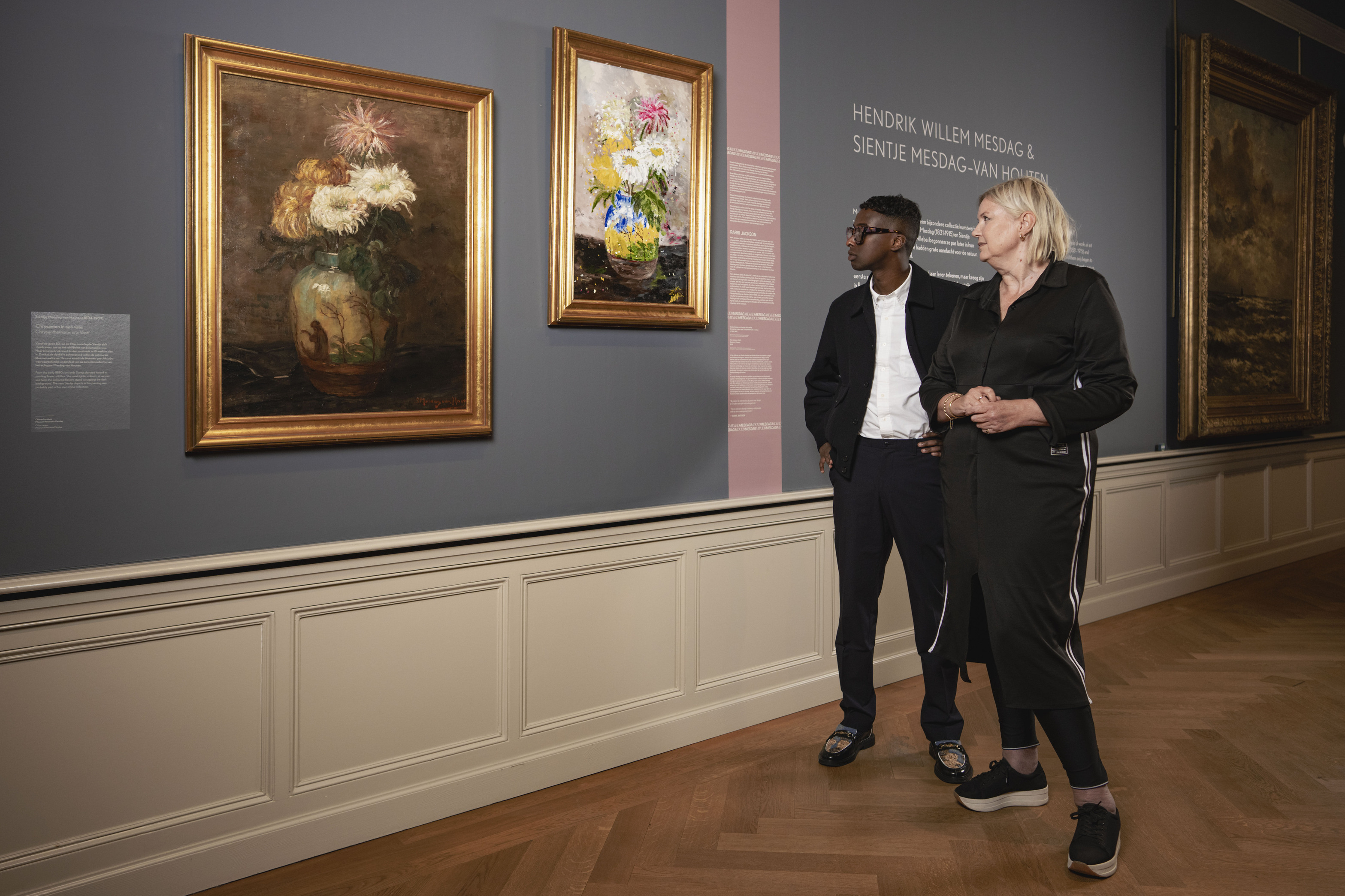 Kunstenaar Rarri Jackson (1997) met museumdirecteur Minke Schat bij zijn werk Bloemen, 2026, acrylverf op doek, in historische lijst uit de museumcollectie.