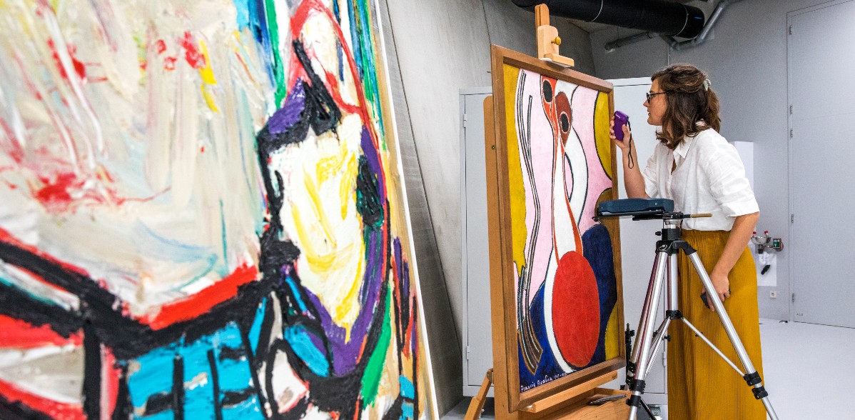 Vrouw onderzoekt modern schilderij in depot van Museum Boijmans