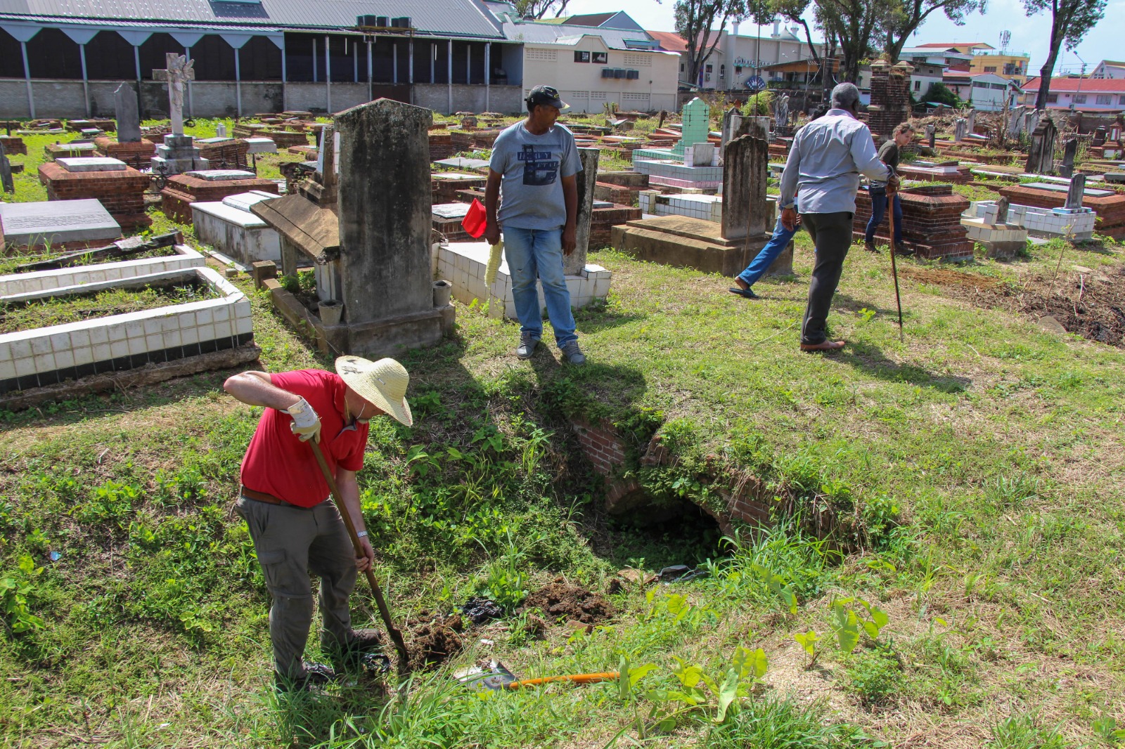 Work on the Nieuwe Oranjetuin in Paramaribo, Suriname – digging for information on the depth of the ditches in the cemetery (photo: René ten Dam). Work on the Nieuwe Oranjetuin in Paramaribo, Suriname – digging for information on the depth of the ditches in the cemetery (photo: René ten Dam).